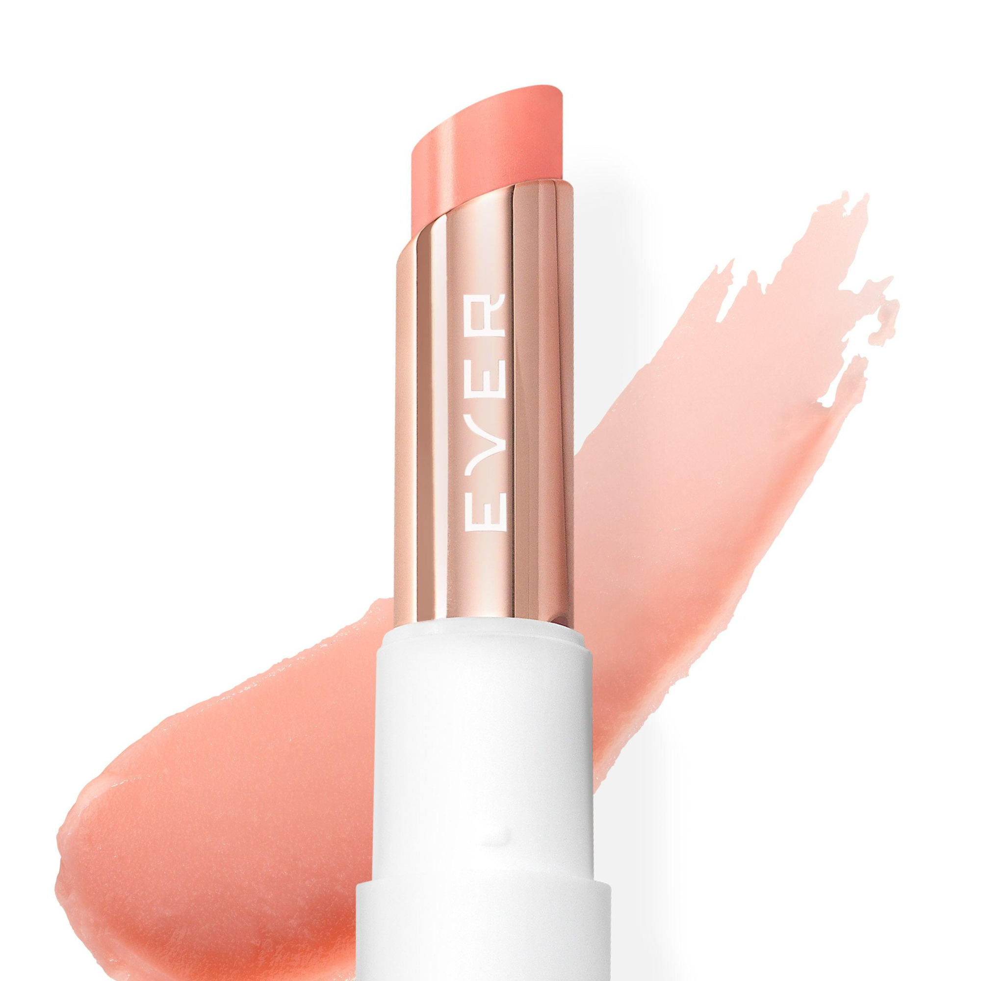 A lip balm stick in an nude color with the brand name EVER written on it, with a sample splash of color against a white background.