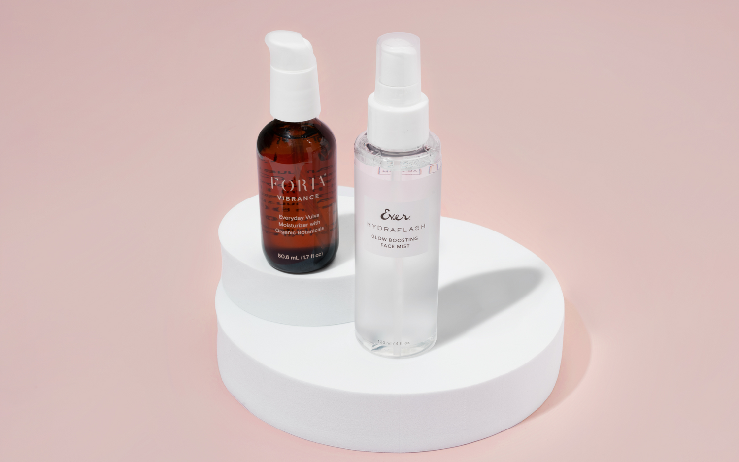 Image of Foria x EVER Stay Dewy Duo on a pink background. Products are: Forias Everyday Vulva Moisturizer, and EVER's Hydraflash Glow Boosting Face Mist.